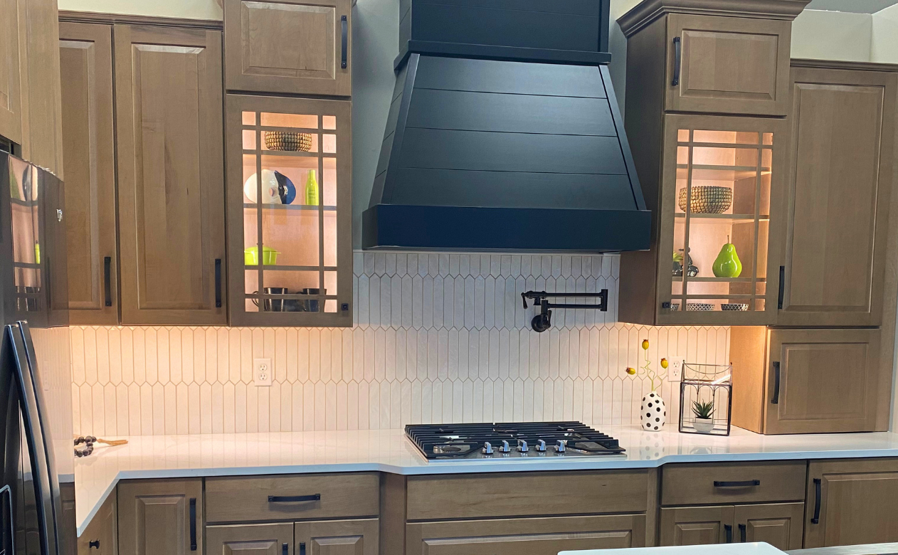 Emerald green tile backsplash in a kitchen with brown and black cabinetry