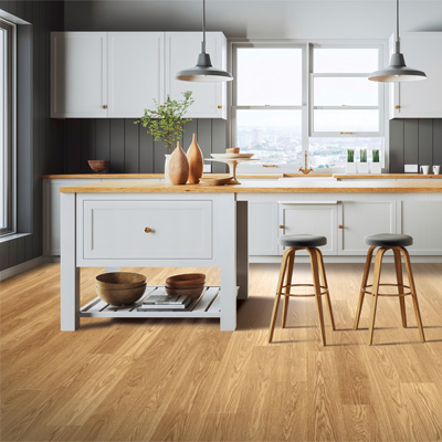laminate flooring in kitchen with grey cabinets and wooden stools
